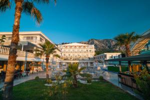 安塔利亚SL La Perla Hotel Kemer的棕榈树和山 ⁇ 的度假村
