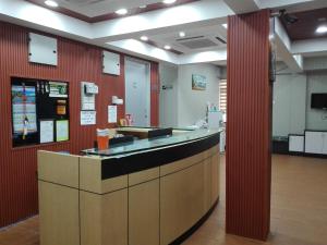 古邦阁亮Bintang Square Hotel的一个带柜台和红色墙壁的办公大厅