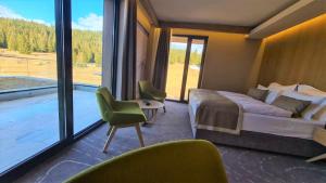 Hotel Monti Spa & Wellness的酒店客房设有一张床和一个大窗户