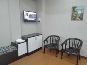 古邦阁亮Bintang Square Hotel的一间房间,配有两把椅子和一台电视