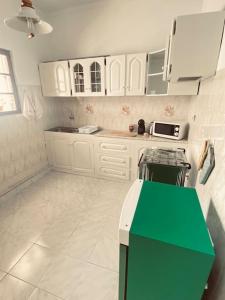 普拉亚Apartamento Siomaly - Piscina的厨房配有白色橱柜和绿色柜台。
