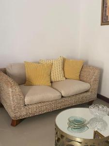 普拉亚Apartamento Siomaly - Piscina的客厅配有柳条沙发,设有桌子