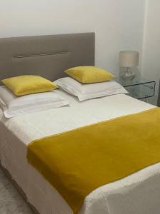 普拉亚Apartamento Siomaly - Piscina的一张带黄色毯子和枕头的床