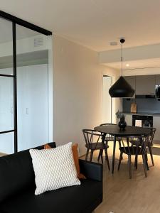 于韦斯屈莱Tikka Apartments的客厅配有黑色沙发和桌子