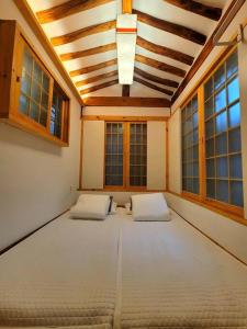 首尔Seoul, Hanok Stay Kyeongaejae的大房间,设有两张床铺和窗户