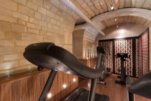 巴黎罗切斯特香榭丽舍酒店的一个带跑步机和砖墙的健身房