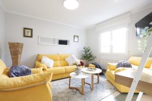 里瓦德奥Casa Flor Delfin Ribadeo的客厅配有黄色的沙发和桌子