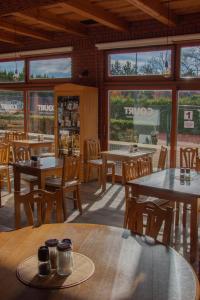 日恰尼奥扎察尼酒店的餐厅设有桌椅和窗户。