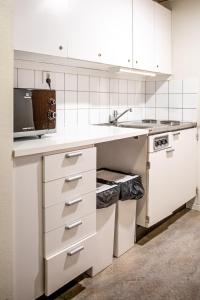 博伦厄酷普伦酒店的白色的厨房配有白色橱柜和水槽