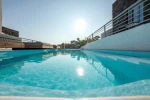 安坡里奥圣托里尼BlackStone Luxury Suites的清澈 ⁇ 蓝的海水游泳池