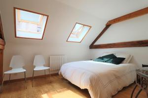 巴斯洛内特Superbe appartement esprit chalet的一间卧室配有一张床和两把白色椅子