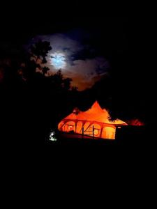 TábuaArambha Ecovillage Permaculture Farm的帐篷在晚上与月亮一起亮起