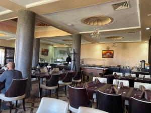 伊尔富德Palais Du Desert Hotel & Spa的一间带桌椅的餐厅和一间酒吧
