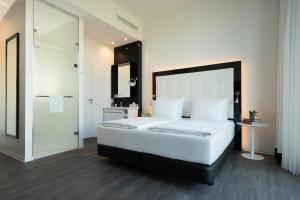 莱比锡INNSiDE by Meliá Leipzig的卧室配有一张白色大床和镜子