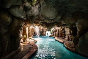 奥兰多Hyatt Regency Grand Cypress Resort的一个带瀑布的岩石洞穴中的游泳池