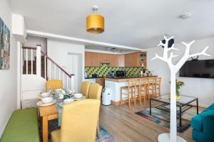 伦敦- Cozy 3 Bed House on a Quiet Mews -的客厅以及带桌椅的厨房。