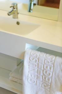 里格斯堡里格斯酒店的浴室水槽和柜台上的白色毛巾