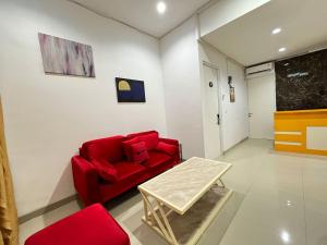 PanikiRedDoorz at Ring Road II Area Manado的客厅配有红色的沙发和桌子