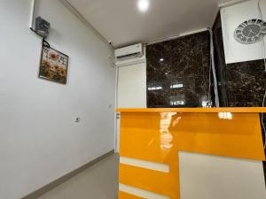 PanikiRedDoorz at Ring Road II Area Manado的一间设有橙色柜台和窗户的客房
