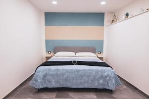 那不勒斯[Centro Storico] Luxury Suites的一间卧室配有一张蓝色和白色墙壁的床