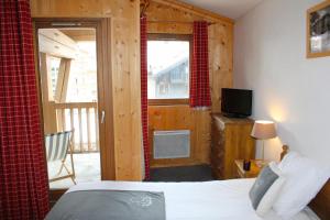 瓦勒迪泽尔Résidence Alpina Lodge by Valdiski的一间卧室设有一张床,阳台配有电视。