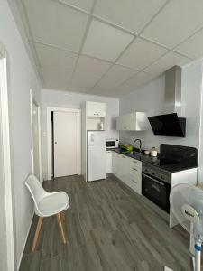 穆拉Apartamento Gabarron的厨房配有白色家电和白色椅子