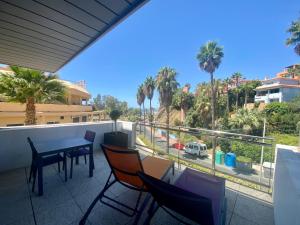 贝纳尔马德纳ArtPlatinum SUITES&APARTMENTS的阳台配有桌椅和棕榈树。