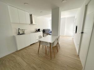 帕尔斯Apartamento Galiria, Pals的白色的厨房配有白色的桌子和椅子