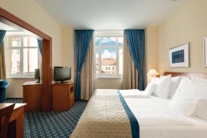 布拉格华美达布拉格市中心酒店的酒店客房,配有床和电视