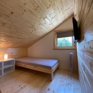 SloupChata Pod kaplí的小屋内带床和窗户的房间