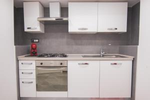 那不勒斯[Centro Storico] Luxury Suites的白色的厨房配有白色橱柜和水槽