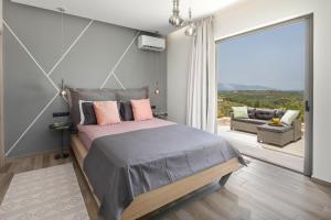 派莱卡斯Villa Tolena的一间卧室设有一张大床和一个大窗户
