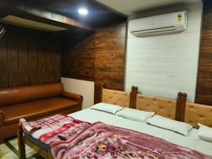 马图拉Hotel Shubhadra Guest House的一间卧室配有一张床、一张沙发和空调