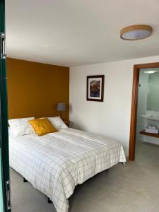 圣巴尔托洛梅HOTEL-FINCA Rural José Manuel 28pax的一间卧室配有一张黄色枕头的床