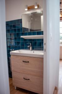 卡纳克Maison vue sur les alignements de Carnac - Les Glycines的浴室配有水槽和蓝色瓷砖墙。