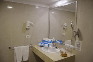 圣乌尔苏拉Residencial La Quinta Park Suites的一间带水槽和镜子的浴室