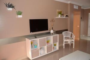 圣乌尔苏拉Residencial La Quinta Park Suites的客厅配有电视和椅子
