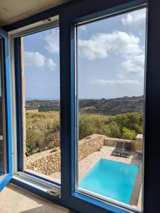 纳杜尔Sea Holly Gozo的从带游泳池的房子的窗户欣赏美景