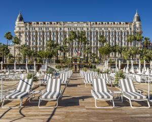 戛纳Carlton Cannes, a Regent Hotel的建筑物前的一排椅子