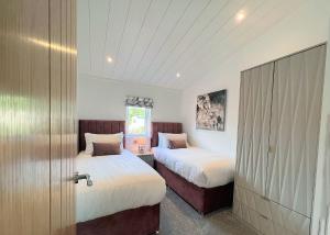 奇平Bowland Escapes的一间卧室设有两张床和推拉门