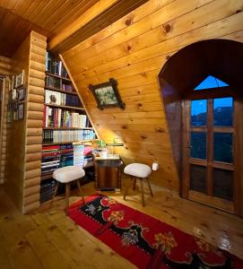 普列夫利亚Household Jakic的一间设有两把椅子、一张桌子和一个书架的房间