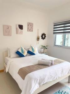 莫阿尔博阿Sunset Paradise Moalboal的卧室配有带蓝色枕头的大型白色床