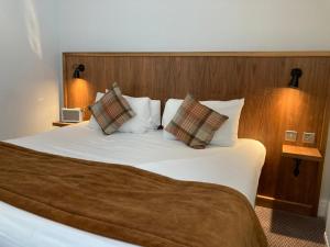 克努斯福德The Cross-Keys Hotel的卧室配有一张带两个枕头的大白色床