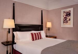 伦敦圣尔敏酒店 - 傲途格精选酒店的一间卧室配有一张带两盏灯的大型白色床。