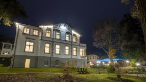 赛巴特班森Ostseehotel Villen im Park - ein Rovell Hotel的一座在晚上有灯的大建筑