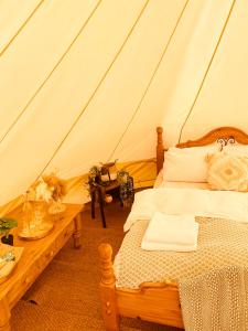 剑桥Fen meadows glamping - Luxury cabins and Bell tents的帐篷内一间卧室,配有一张床