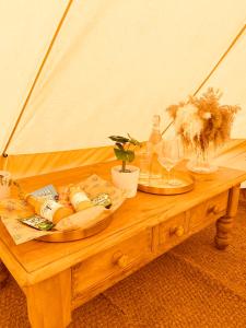 剑桥Fen meadows glamping - Luxury cabins and Bell tents的一张木桌,上面放着两盘食物