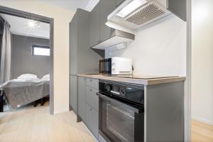 奥斯陆Forenom Serviced Apartments Oslo Munch的带微波炉和炉灶的小厨房