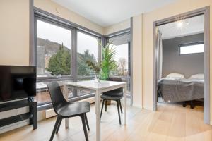 奥斯陆Forenom Serviced Apartments Oslo Munch的一间带桌椅的客厅和一间卧室