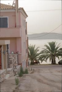 波多河丽Niriides Apartments的一座棕榈树的粉红色建筑
